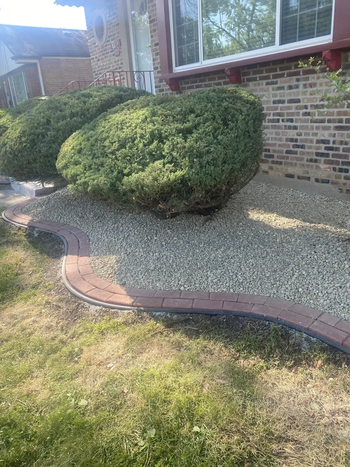 Trimmed shrubs and gravel installation